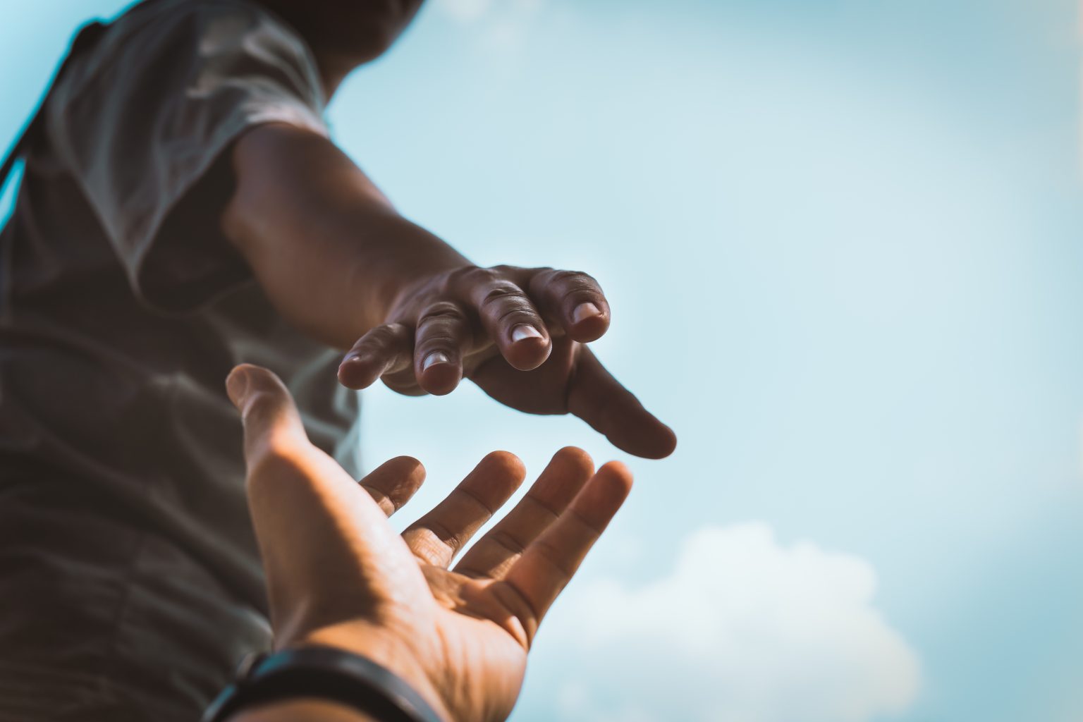 Help Concept hands reaching out to help each other in dark tone